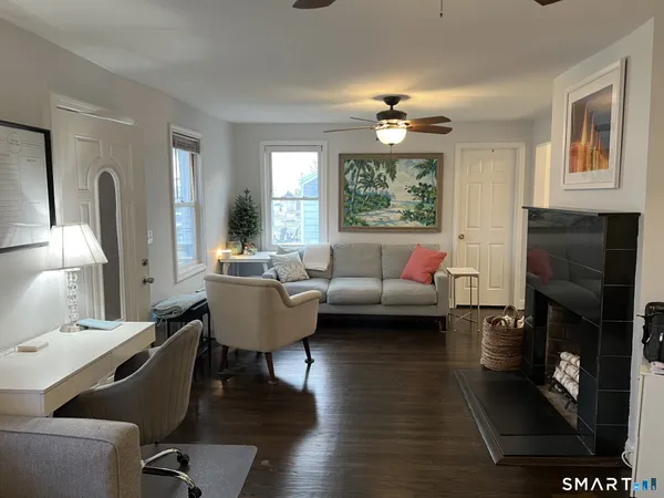 a living room with furniture a fireplace and a window