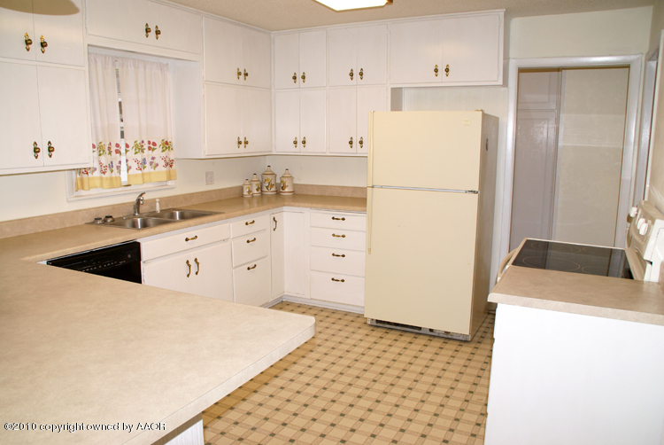 5124 Arden Road Amarillo, TX 79110 - Photo 12 of 42 a kitchen with granite countertop a refrigerator sink stove and white cabinets