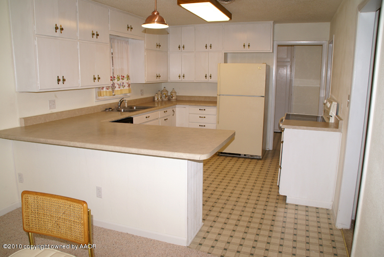 5124 Arden Road Amarillo, TX 79110 - Photo 13 of 42 a kitchen with a sink a refrigerator and a stove