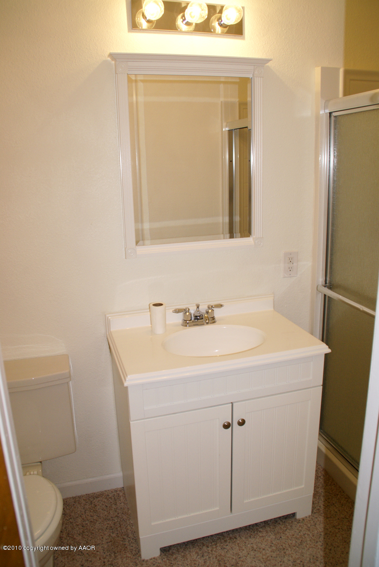 5124 Arden Road Amarillo, TX 79110 - Photo 18 of 42 a bathroom with a sink a toilet and mirror