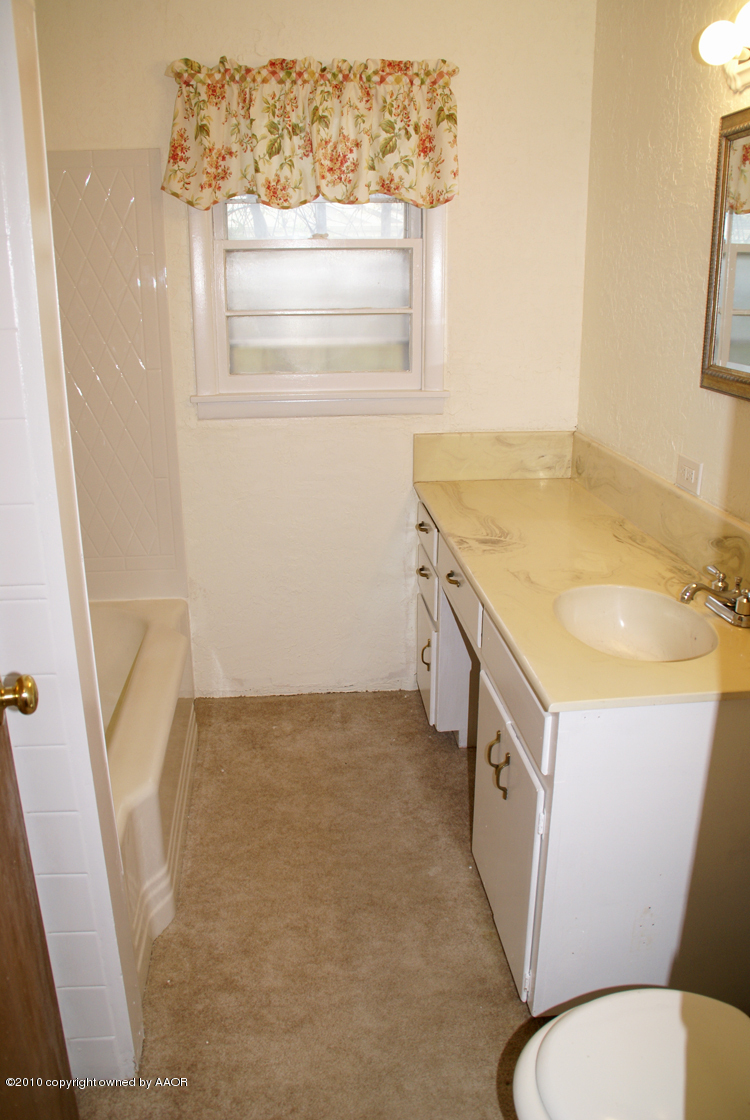 5124 Arden Road Amarillo, TX 79110 - Photo 24 of 42 a bathroom with a sink a toilet and a mirror
