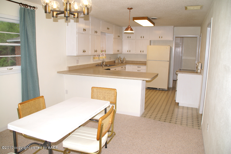 5124 Arden Road Amarillo, TX 79110 - Photo 9 of 42 a kitchen with a table chairs refrigerator and cabinets