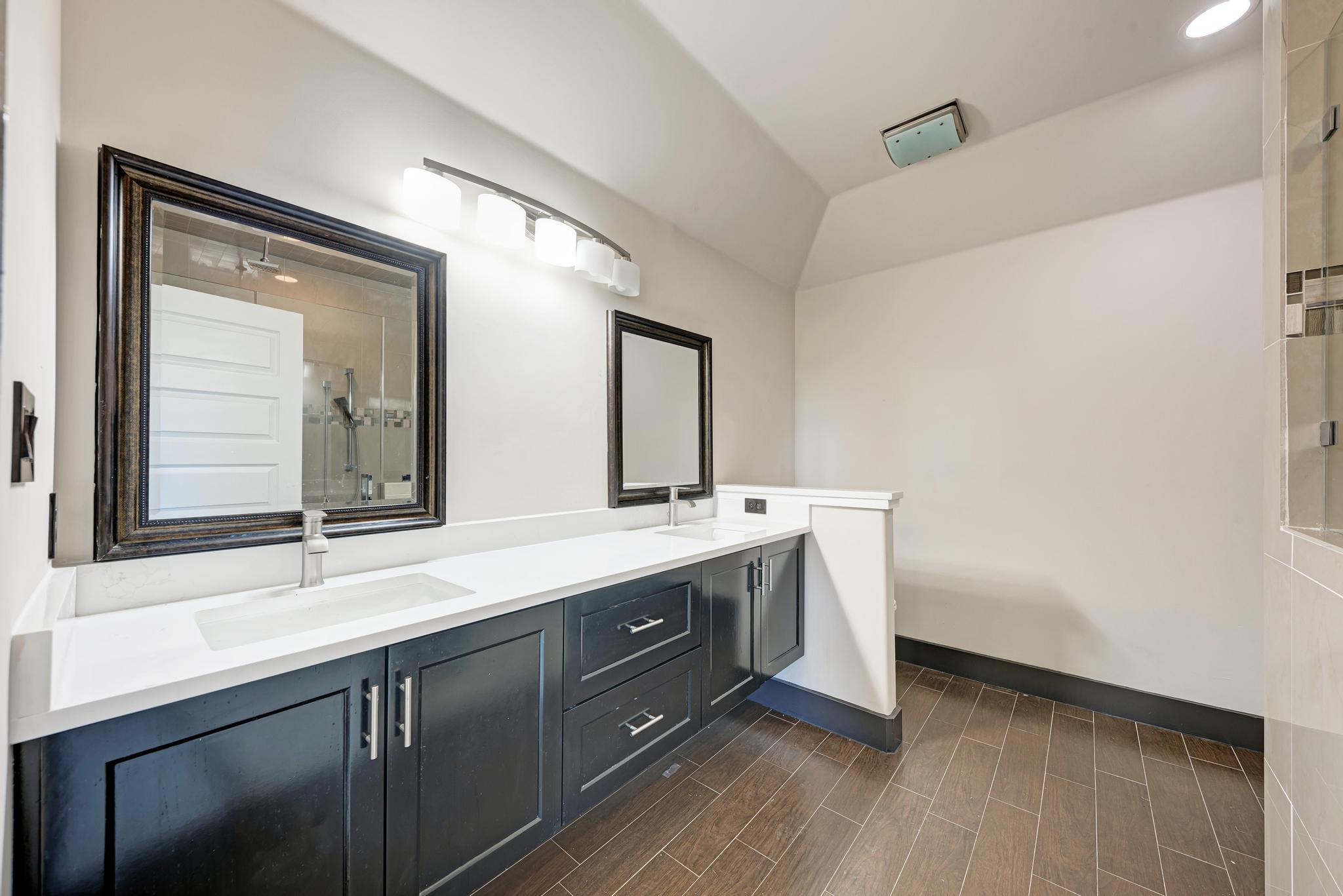 104 Spring Valley Street Hutto, TX 78634 - Photo 22 of 40 Bathroom featuring double vanity, a shower stall, wood tiled floors, and vaulted ceiling