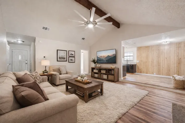 a living room with furniture a large window and a flat screen tv