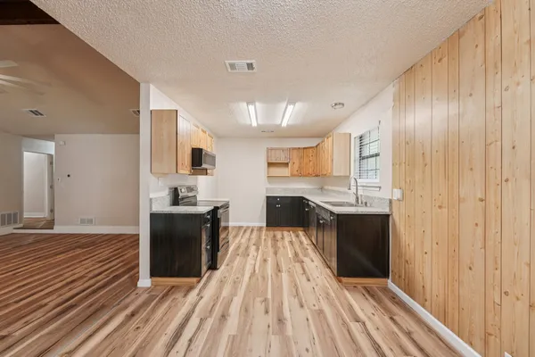 a large kitchen with a sink and stainless steel appliances