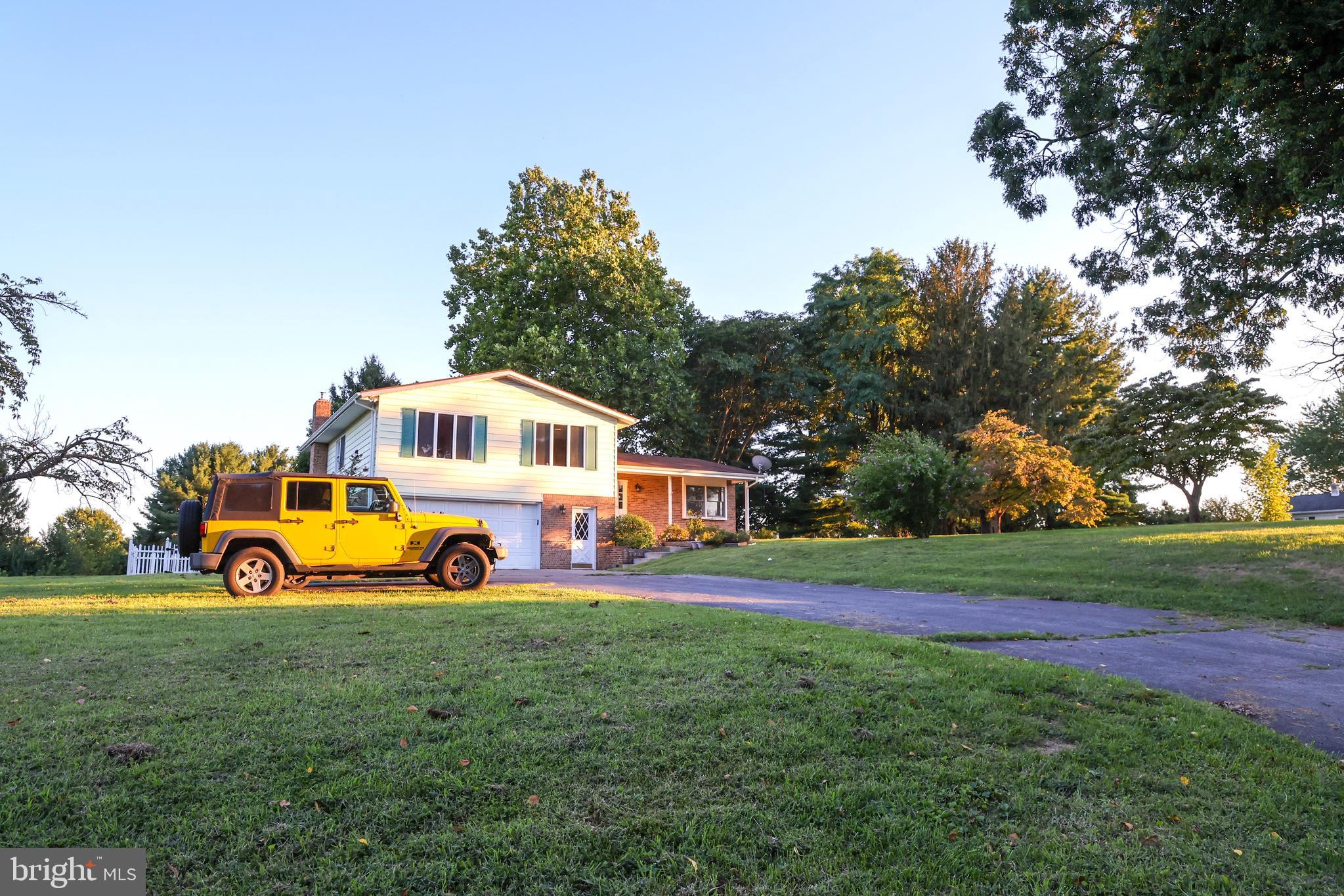 19717 Toms Road Boonsboro, MD 21713 - Photo 49 of 60 a view of a white house in front of a big yard with plants and large trees