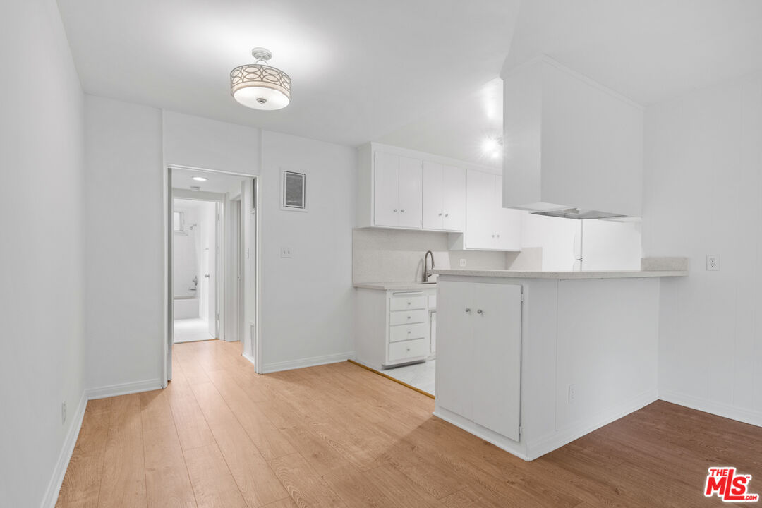 a kitchen with cabinets appliances and a wooden floor