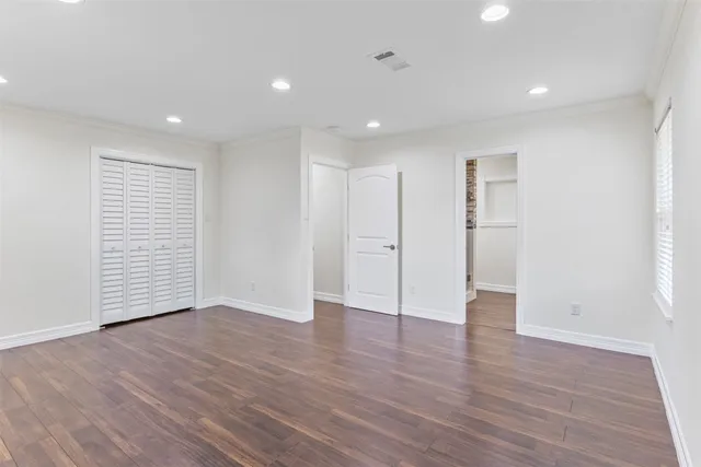 a view of an empty room with wooden floor and entryway