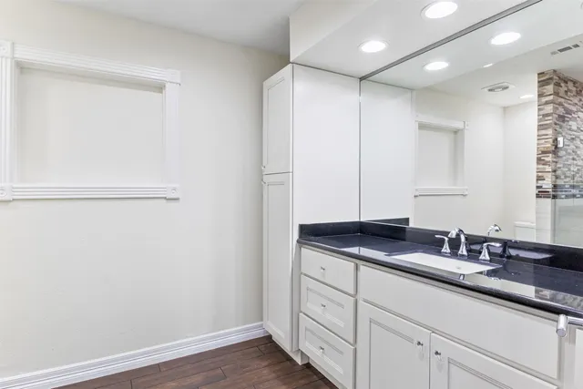 a bathroom with a granite countertop sink and a mirror