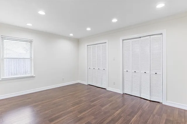 a view of an empty room with wooden floor and entryway