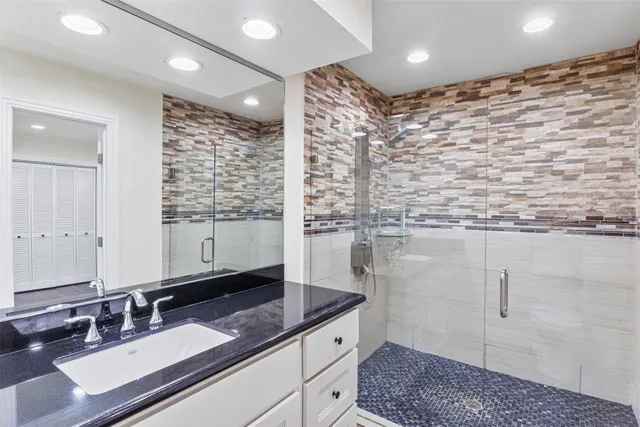 a bathroom with a double vanity sink a mirror and a shower