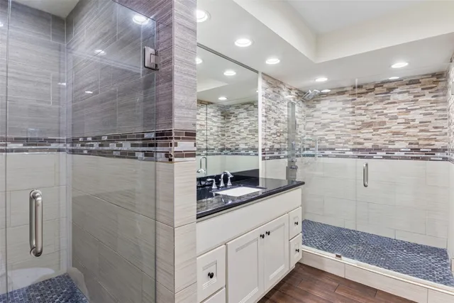 a bathroom with a granite countertop sink a toilet and a shower