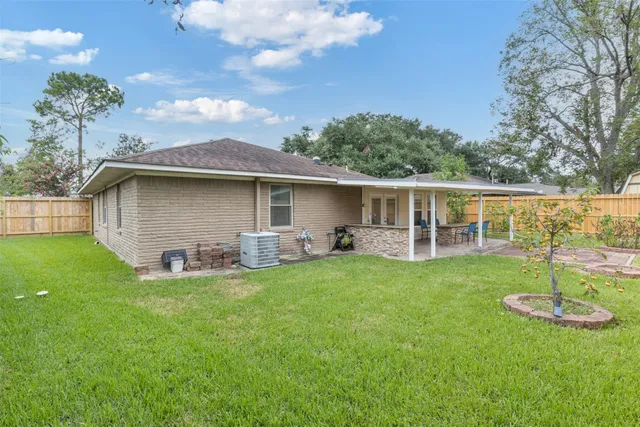 a view of a house with a backyard and a patio