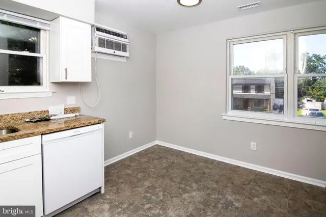a kitchen with a stove cabinets and a window