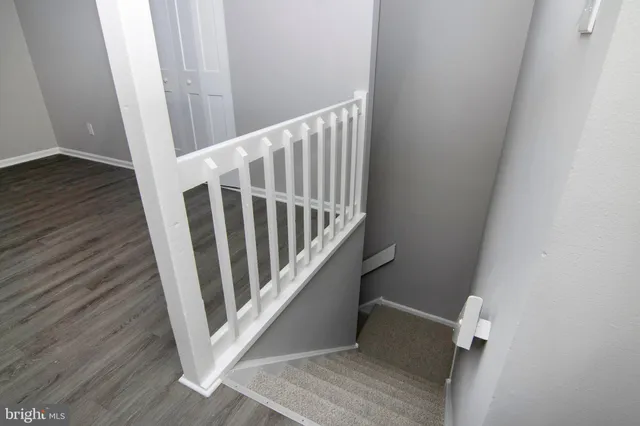 a view of staircase with white walls and white door