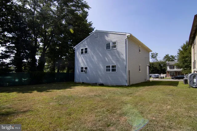 a view of a house with backyard and trees