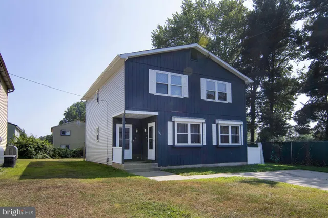 a view of a yard in front of a house with large trees