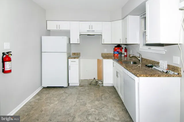 a kitchen with white cabinets and white appliances