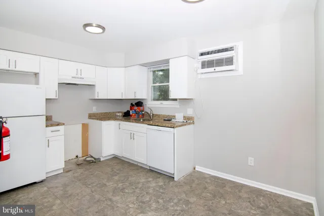 a kitchen with granite countertop white cabinets and white appliances