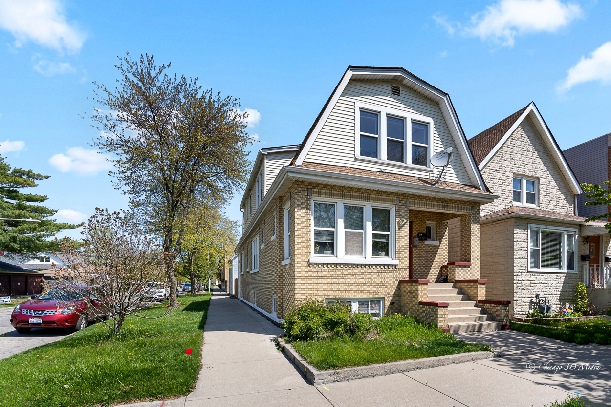 4954 West Byron Street Chicago, IL 60641 - Photo 1 of 42 a front view of a house with a yard