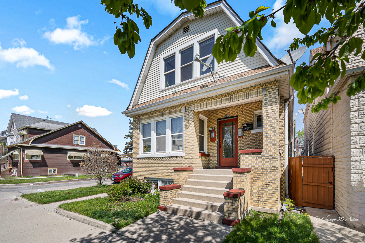 4954 West Byron Street Chicago, IL 60641 - Photo 40 of 42 a front view of a house with a yard