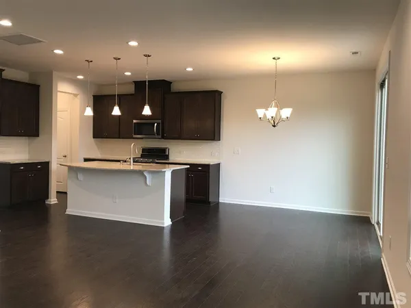 a view of kitchen with granite countertop stainless steel appliances and wooden floor
