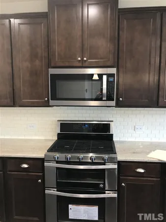 a stove top oven sitting inside of a kitchen
