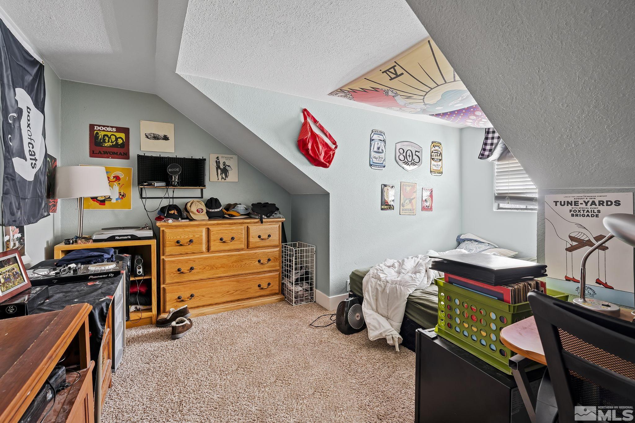 1001 Nevada Street Reno, NV 89503 - Photo 12 of 16 a bedroom with a baby bed a couch and a desk