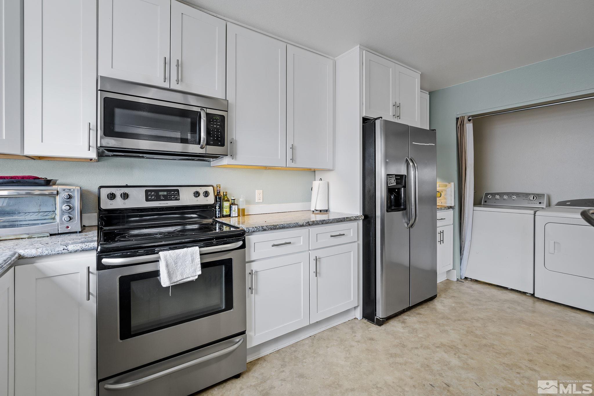 1001 Nevada Street Reno, NV 89503 - Photo 7 of 16 a kitchen with stainless steel appliances white cabinets a stove a microwave and a refrigerator