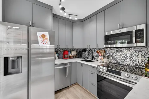 a kitchen with stainless steel appliances granite countertop a refrigerator sink stove and microwave