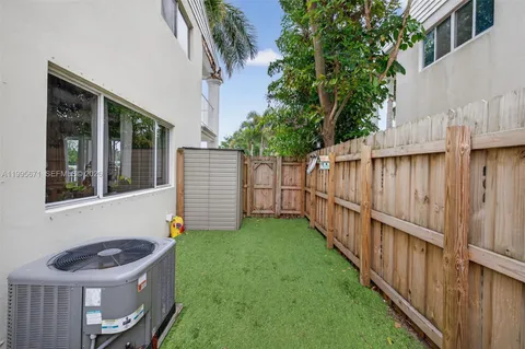 a view of a backyard with plants and brick wall