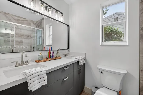 a bathroom with a sink a toilet and shower