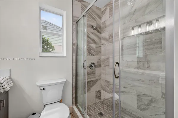 a bathroom with a toilet and shower
