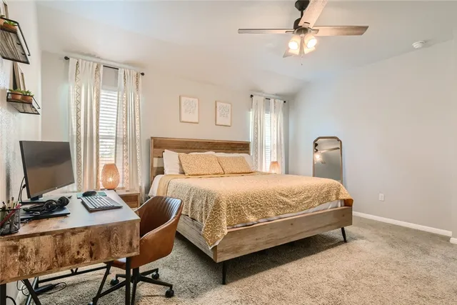 a bedroom with a bed desk and a window