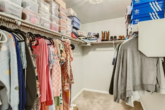 a view of walk in closet with clothes and shoes