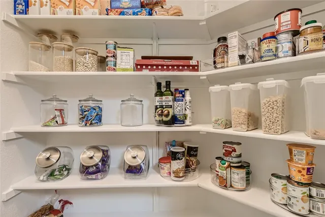 a view of a refrigerator with lots of clutter and cabinets