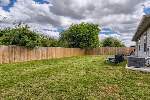 a view of a backyard with table and chairs and wooden fence