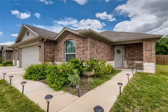 a front view of a house with a garden