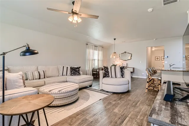 a living room with furniture or chandelier and a wooden floor