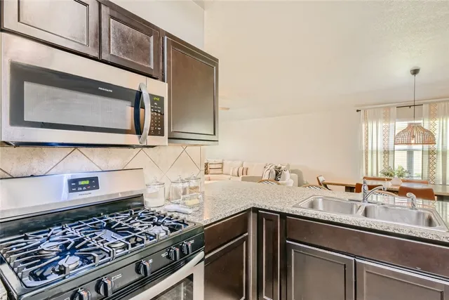 a kitchen with stainless steel appliances a stove and a microwave