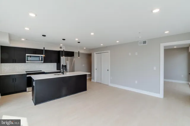a large white kitchen with stainless steel appliances