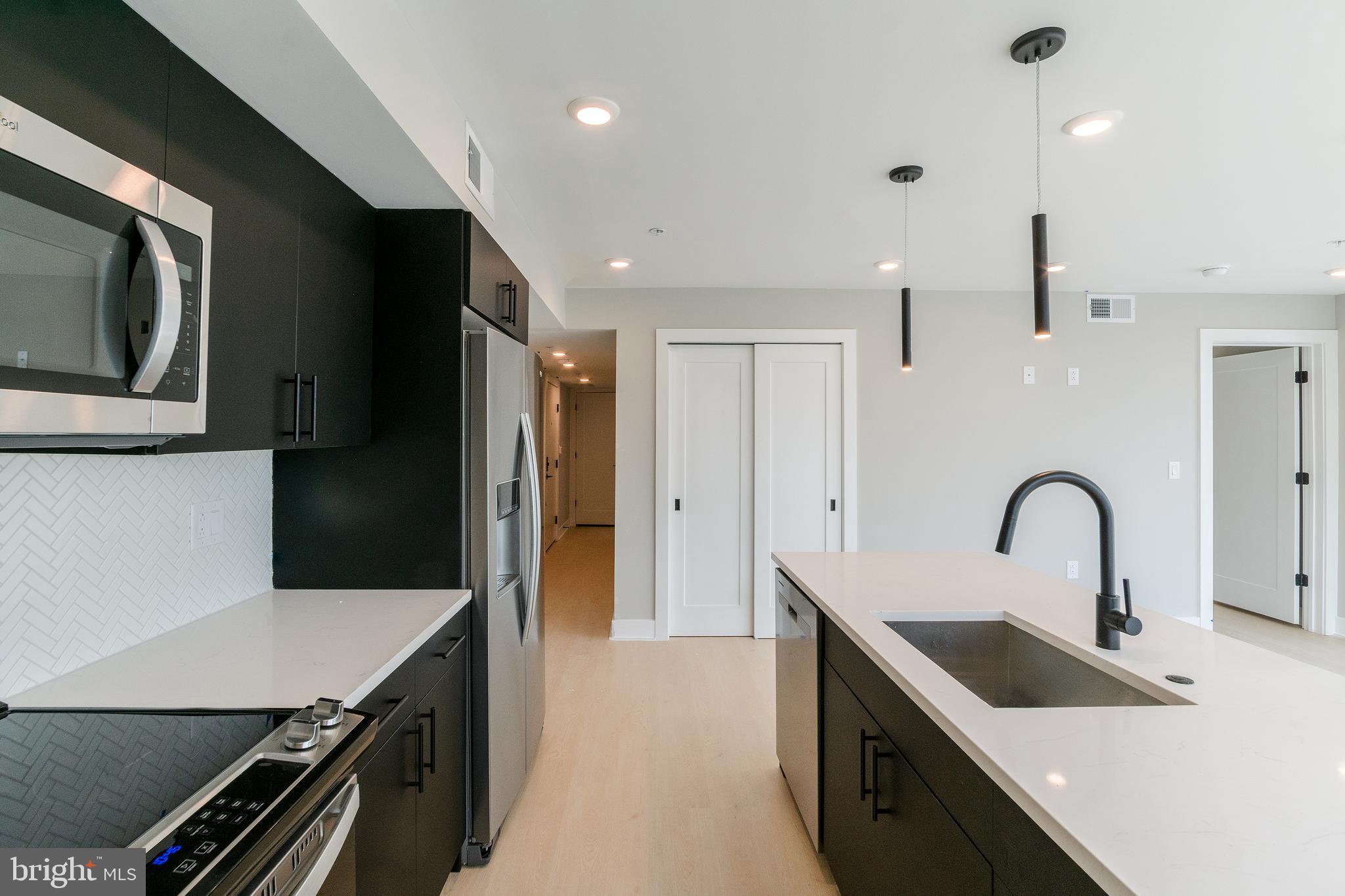 6604 Ridge Avenue, Unit 205 Philadelphia, PA 19128 - Photo 10 of 22 a kitchen with a refrigerator and a sink