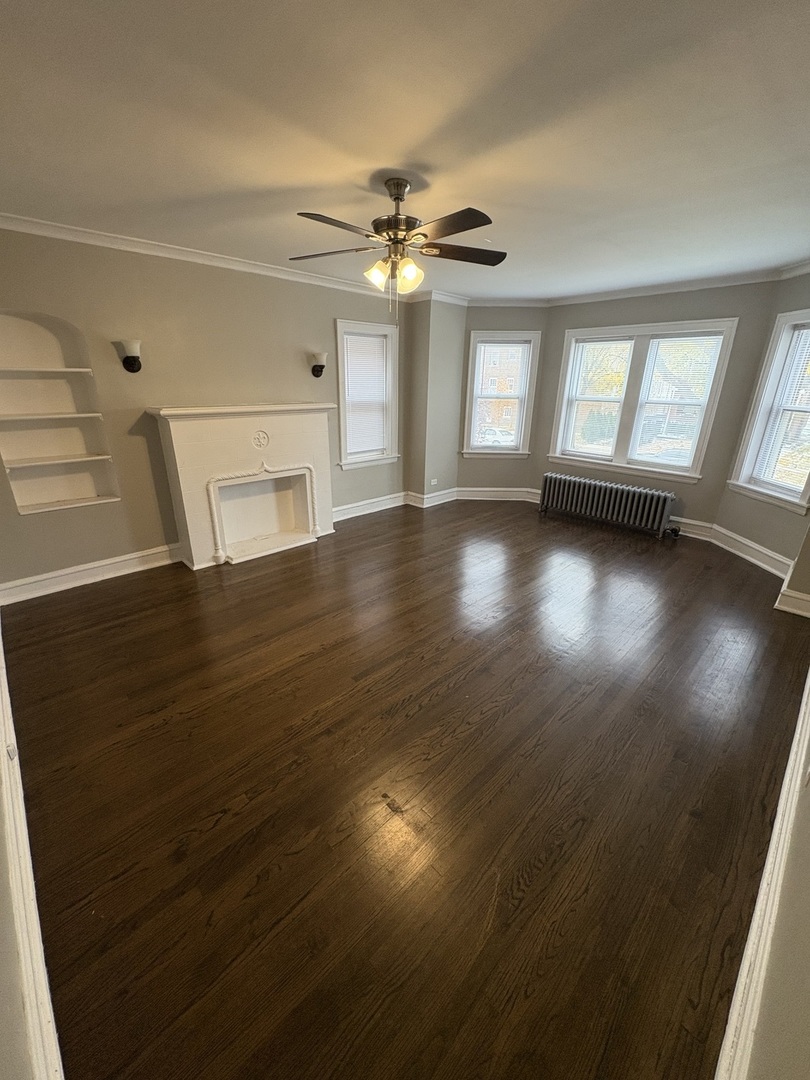 3245 Wisconsin Avenue, Unit 1S Berwyn, IL 60402 - Photo 2 of 10 a view of empty room with wooden floor and fan
