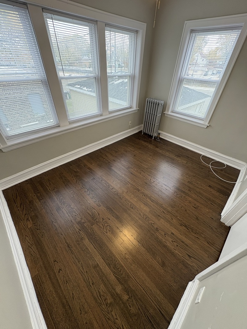 3245 Wisconsin Avenue, Unit 1S Berwyn, IL 60402 - Photo 7 of 10 a view of an empty room with wooden floor and a window