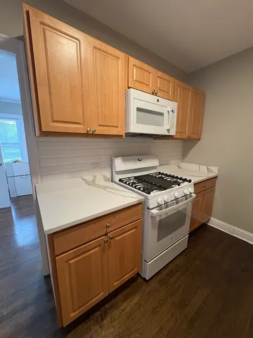 a white stove top oven sitting inside of a kitchen