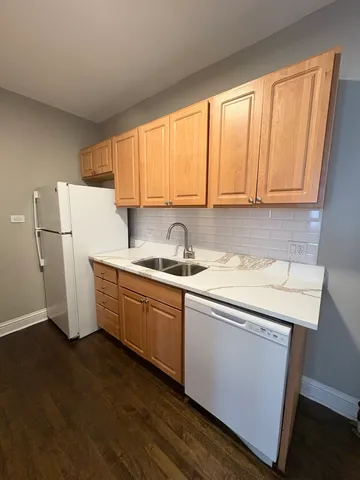 a kitchen with a refrigerator sink and cabinets
