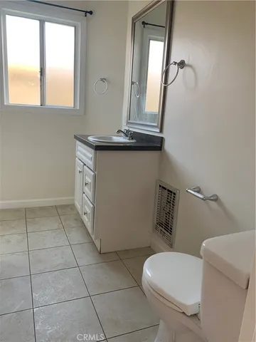 a bathroom with a toilet mirror vanity and window