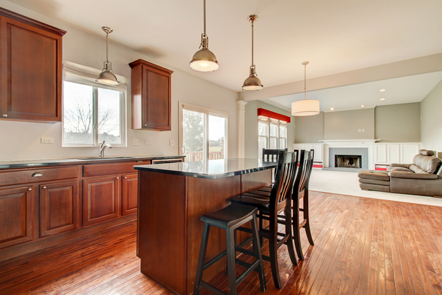 3 Firethorn Court Bolingbrook, IL 60490 - Photo 11 of 39 a kitchen with stainless steel appliances granite countertop a kitchen island hardwood floor sink stove dining table and chairs