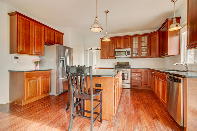 3 Firethorn Court Bolingbrook, IL 60490 - Photo 9 of 39 a large kitchen with stainless steel appliances wooden floors and wooden cabinets