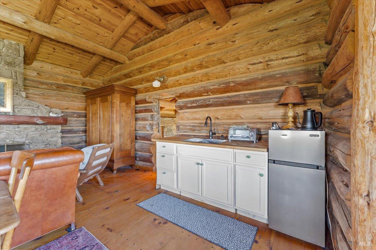 3034 State Line Road Klamath Falls, CA 97603 - Photo 29 of 42 a kitchen with refrigerator cabinets and wooden floor